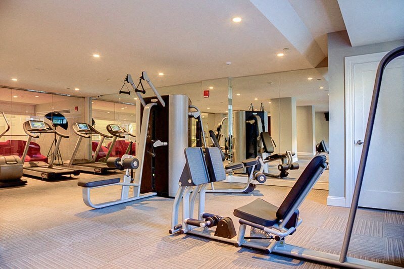 a gym with cardio equipment and weights on the floor