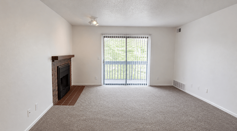 A room with a fireplace and carpeted floor.
