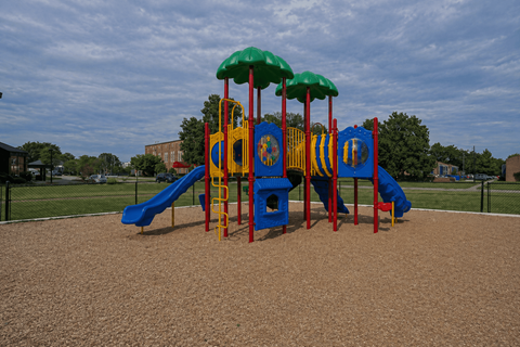 A playground with a blue slide and a yellow and red play structure.