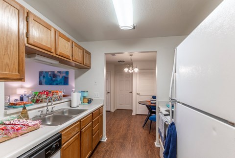 A kitchen with wooden cabinets and a white refrigerator.