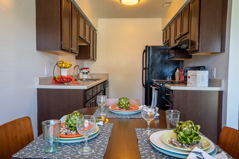 a dining room table with plates of food in a kitchen
