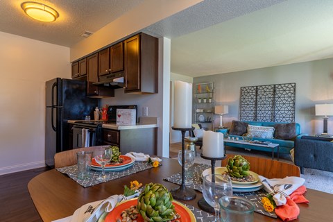 a dining room table with plates of food and a living room with a kitchen