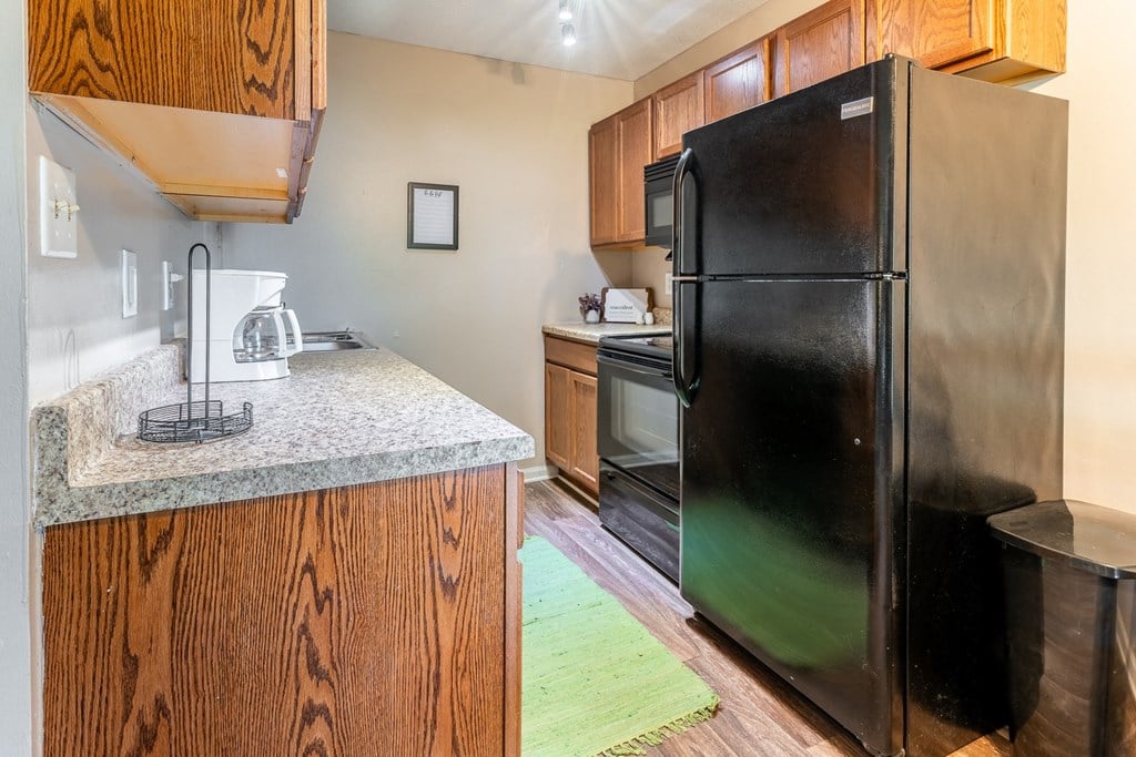 a kitchen with black appliances and a granite counter top