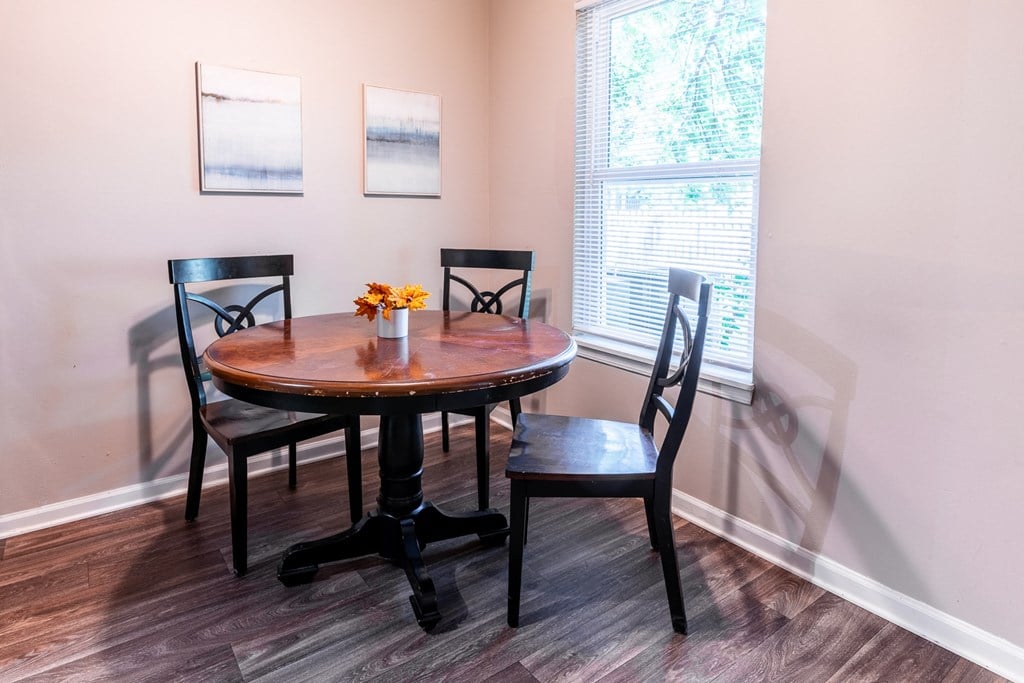 a dining room with a table and chairs and a window