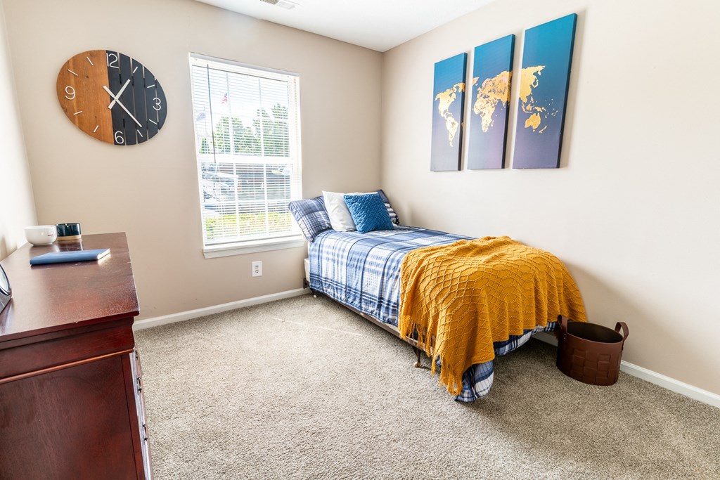 a bedroom with a bed and a clock on the wall