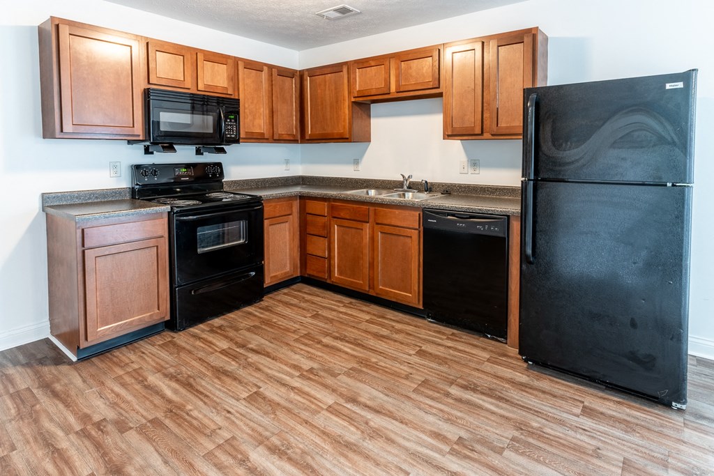 a kitchen with wood flooring and black appliances at HUB of New Albany, New Albany