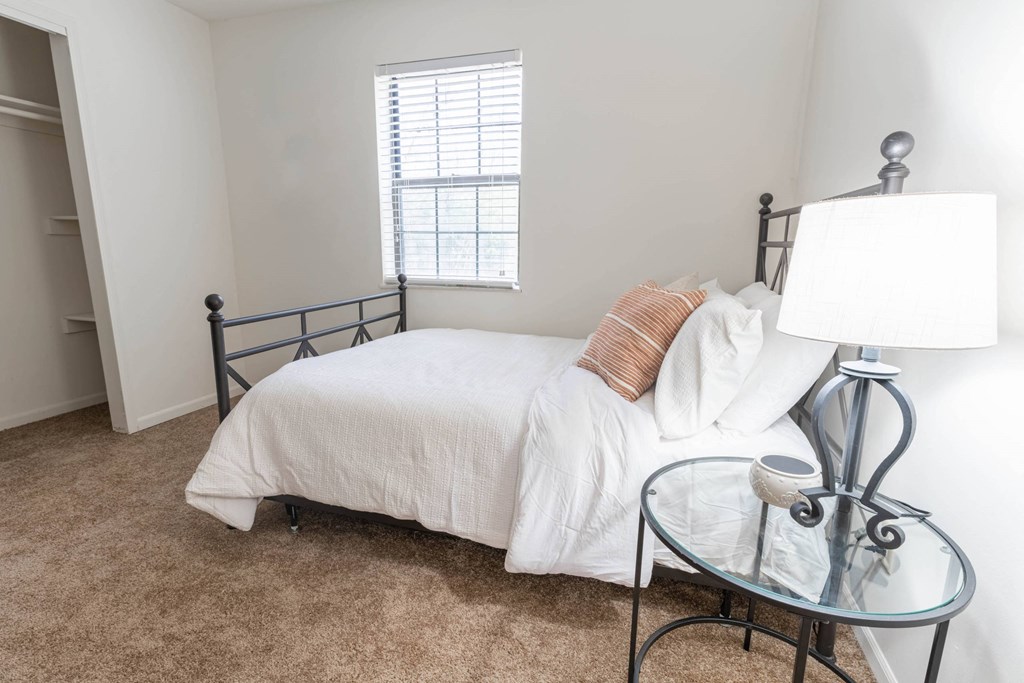 a bedroom with a bed and a table with a lamp