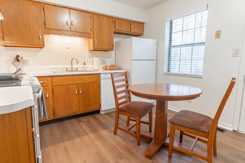 a kitchen with wooden cabinets and a table and chairs