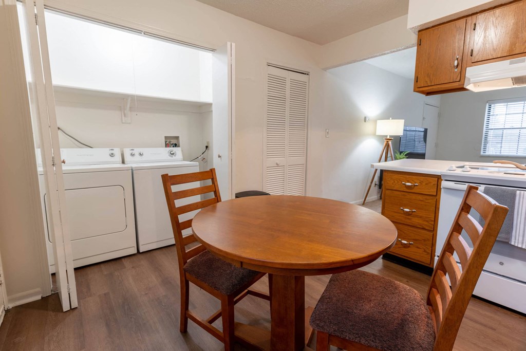 a kitchen with a table and chairs and a washer and dryer