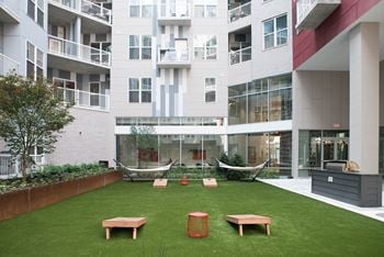 Spacious courtyard with greenspace, games, and a cozy fireplace and lounging at The Whit in Indianapolis, IN 46204