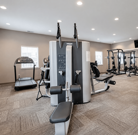 A gym with a treadmill, elliptical trainer, and other exercise equipment.