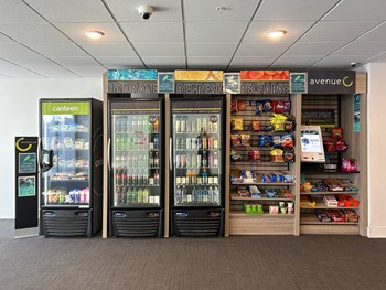 Whit Market with a row of refrigerators with refreshing drinks and snacks at The Whit Apartments in Indianapolis, IN 46204 - Photo Gallery 56