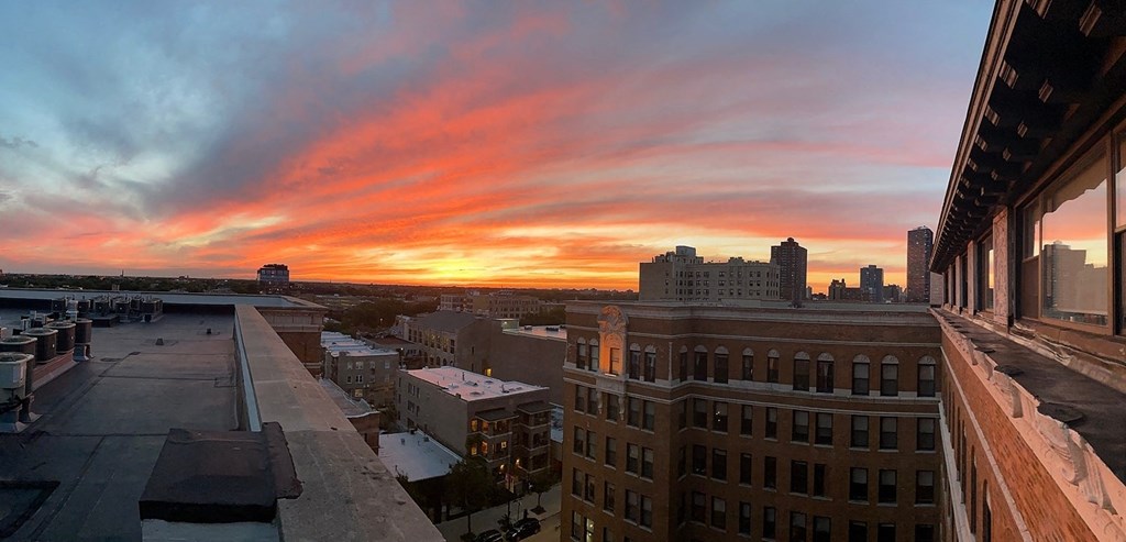 a view of the sunset from the roof of a building in a city