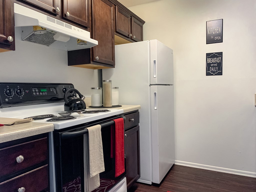 Updated kitchen with wood-style plank flooring at The Lodge Apartments in Indianapolis, IN