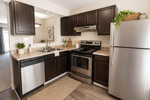 A kitchen with dark brown cabinets and stainless steel appliances.