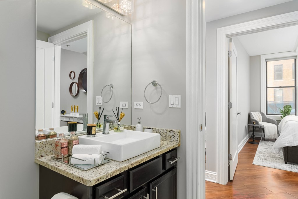 Modern bathroom with Quart countertops and large mirror at Somerset Place Apartments, Illinois, 60640