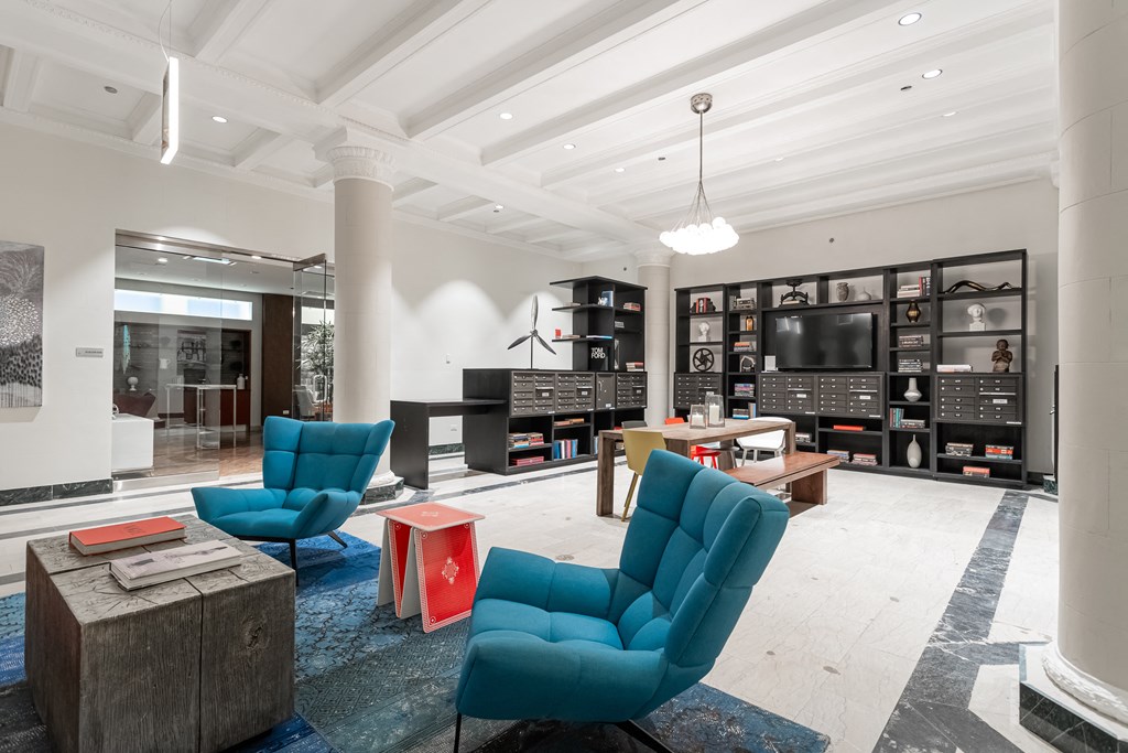 a living room with blue chairs and a television