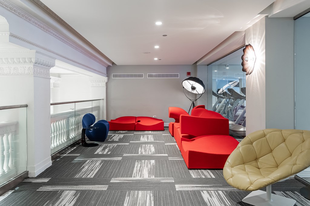 a living room with red furniture and a gray and white floor
