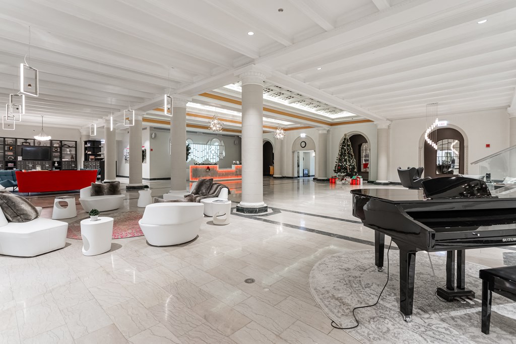 a grand piano sits in the middle of a large room with furniture and a piano