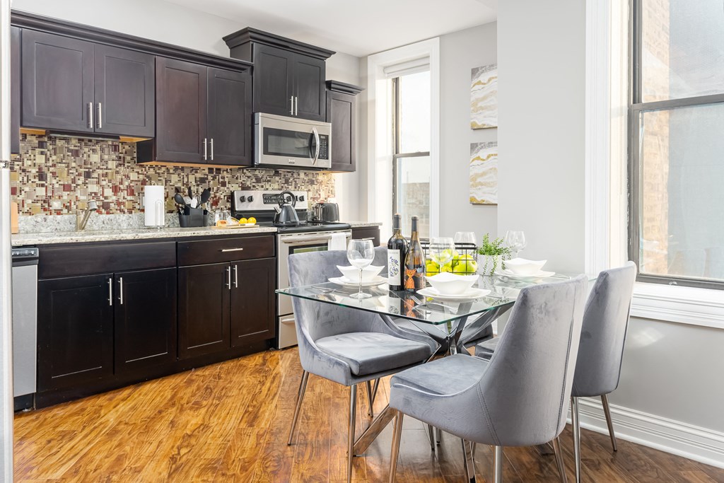a kitchen with black cabinets and a table and chairs