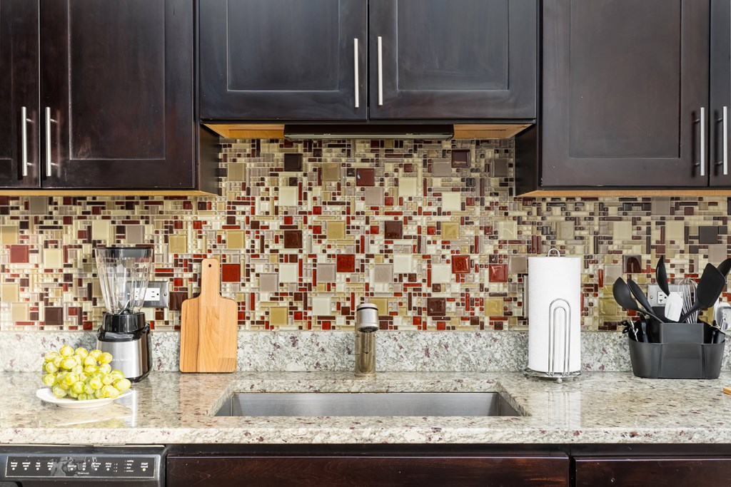 a kitchen counter with a sink and a tile backsplash