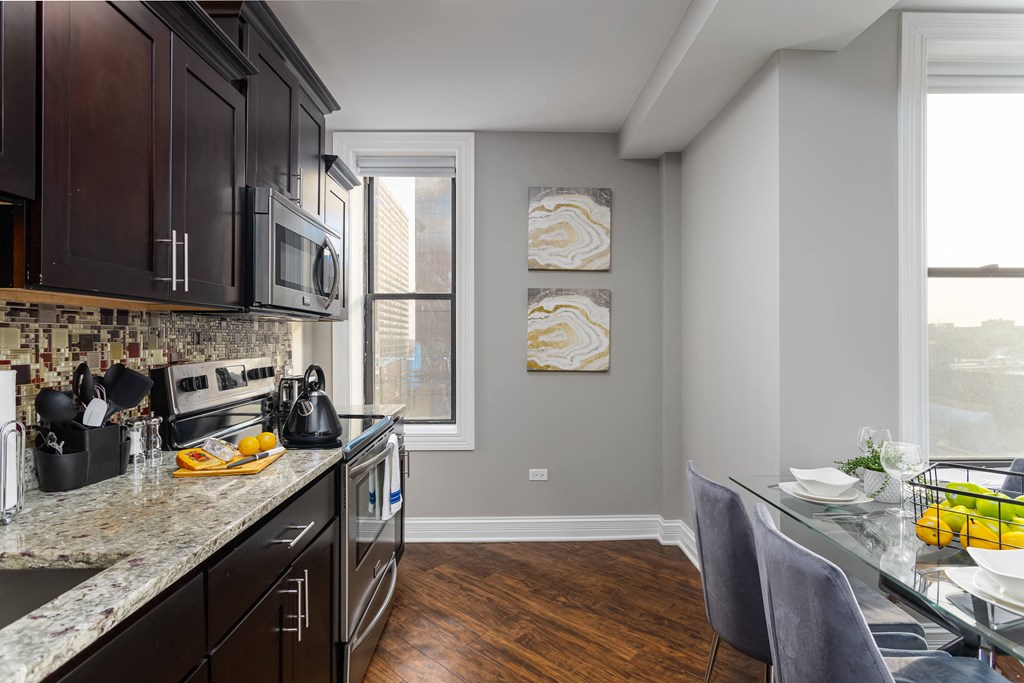 a kitchen with a granite counter top and modern backsplash at Somerset Place Apartments