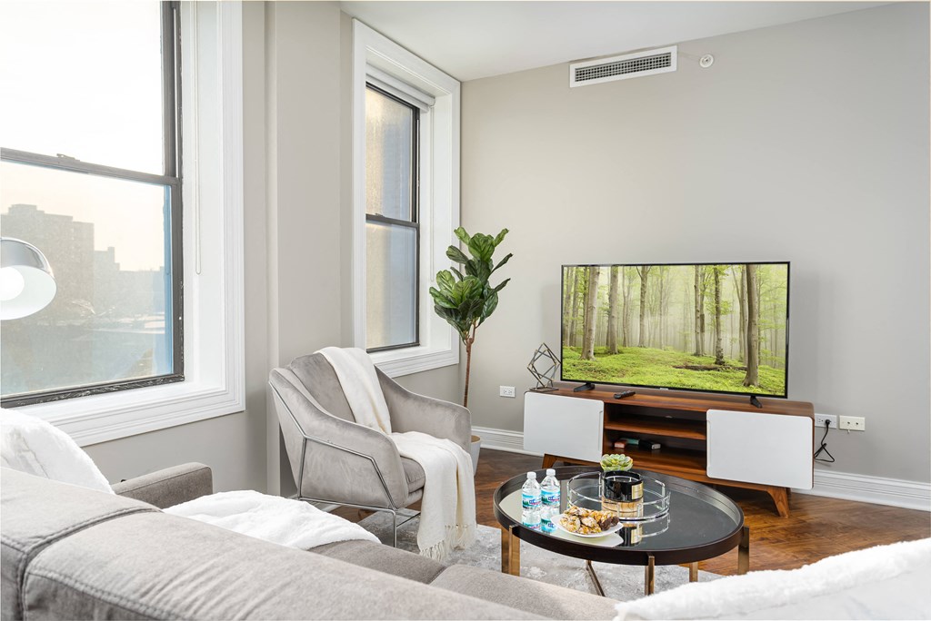 a living room with a couch and a chair and a tv