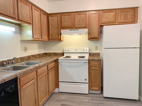 a kitchen with white appliances and wooden cabinets