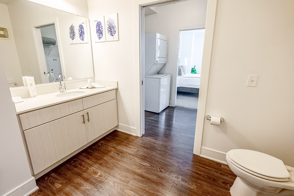 a bathroom with a toilet and a sink and a mirror at The Whit Apartments, Indianapolis, Indiana