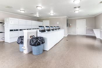 an empty room with white cabinets and trash cans in it