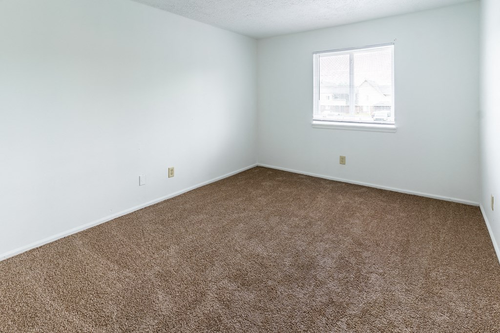 an empty room with carpet and a window at Lake Camelot Apartments, Indiana, 46268