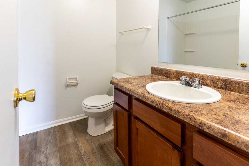 a bathroom with a sink and toilet and a mirror at Lake Camelot Apartments, Indiana, 46268