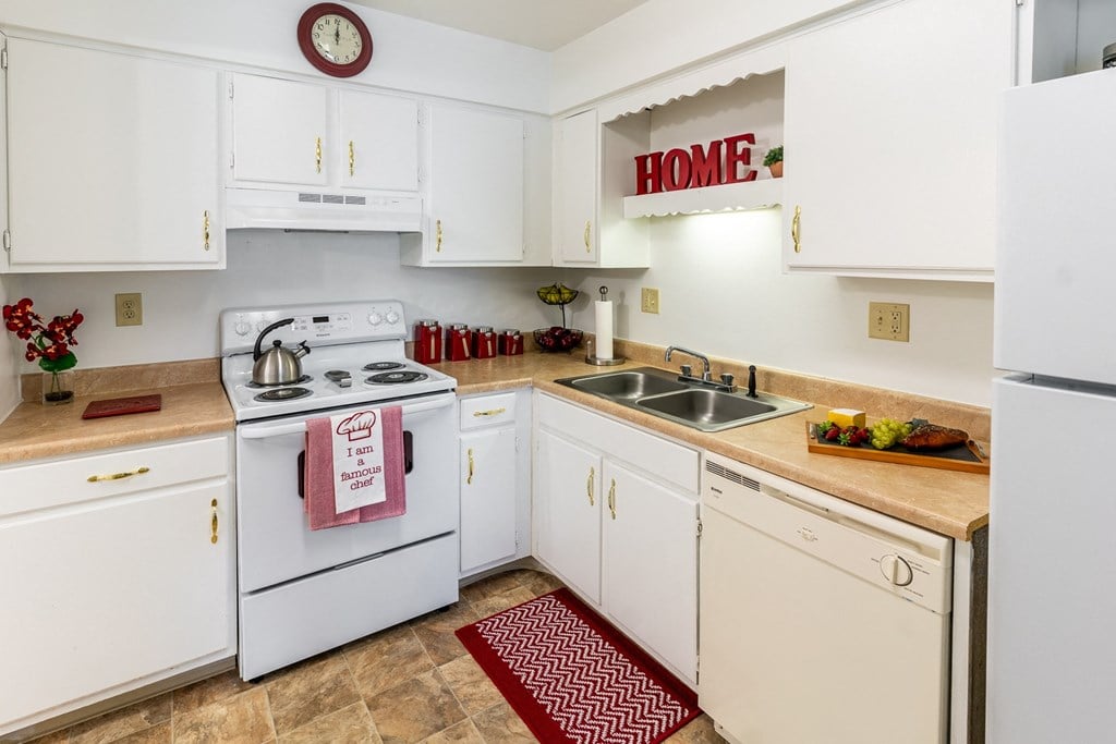 a kitchen with white appliances and white cabinets and a sink