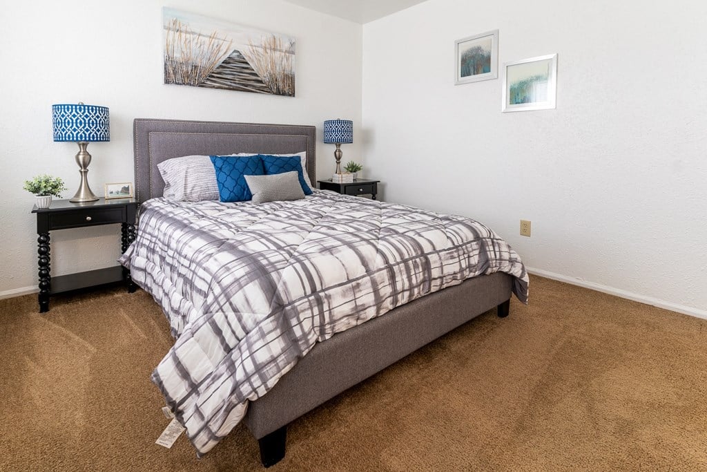 a bedroom with a bed and a dresser with a nightstand and a window