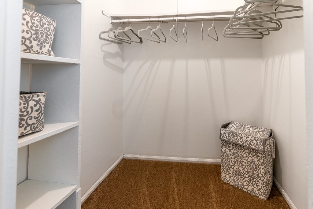 a walk in closet with white walls and shelves and a bag on the floor at Lake Camelot Apartments, Indianapolis, IN