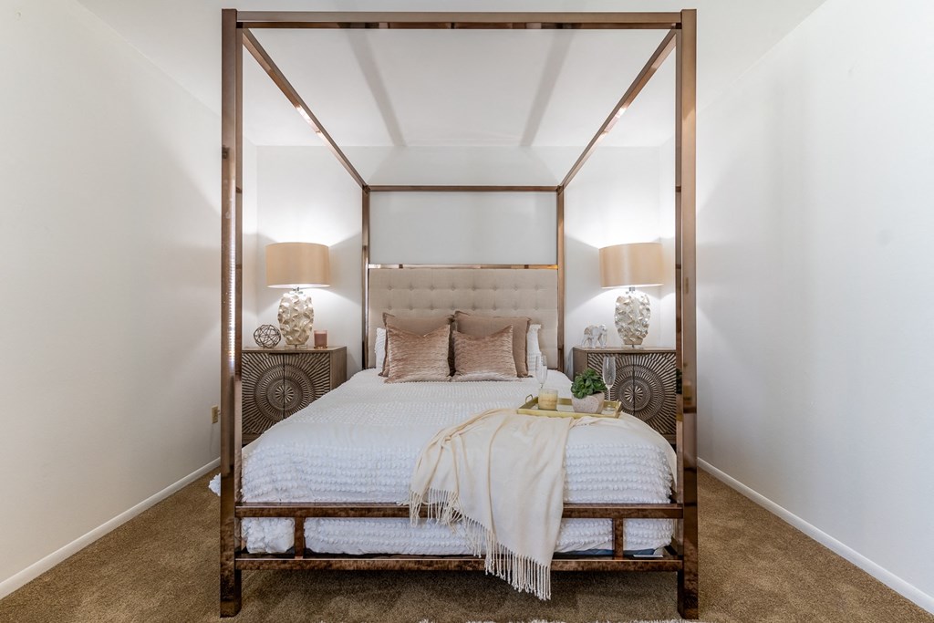 a bedroom with a large bed and two lamps  at Pickwick Farms Apartments, Indianapolis, 46260