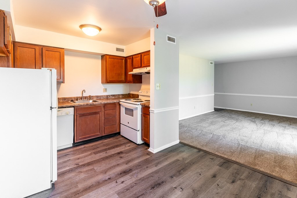 an empty kitchen with wood floors and white appliances at Pickwick Farms Apartments, Indianapolis