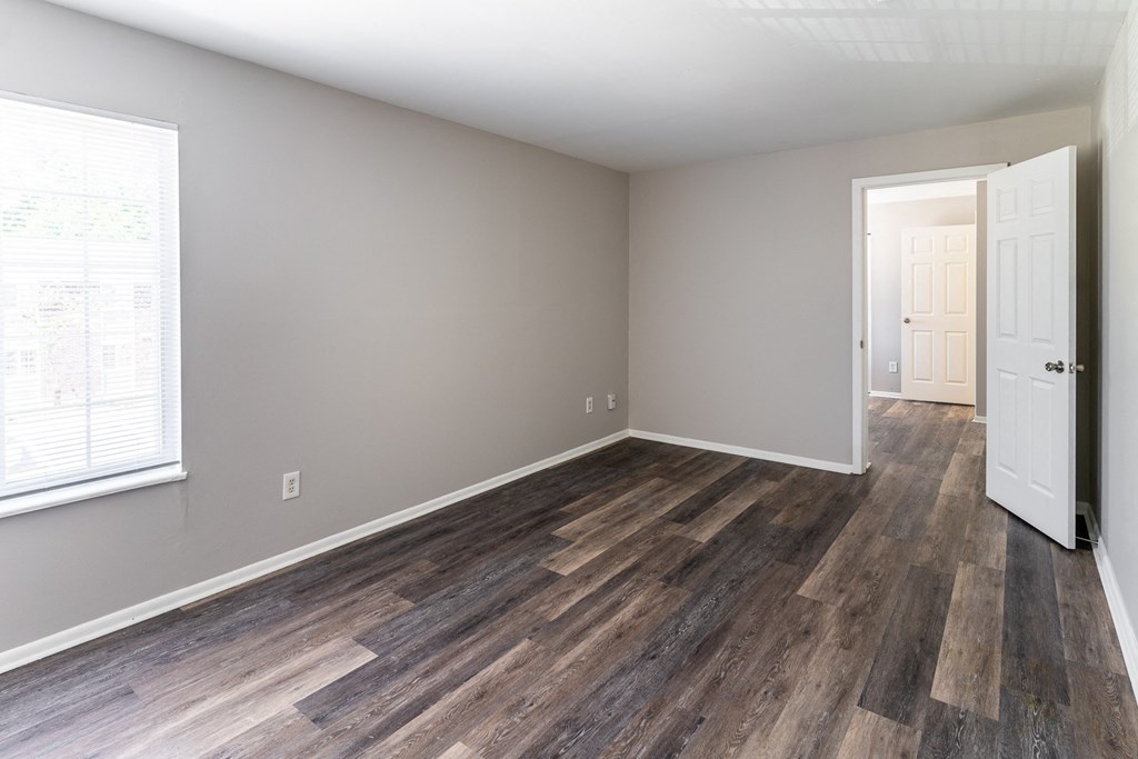 an empty living room with wood flooring and a white door at Pickwick Farms Apartments, Indianapolis, Indiana
