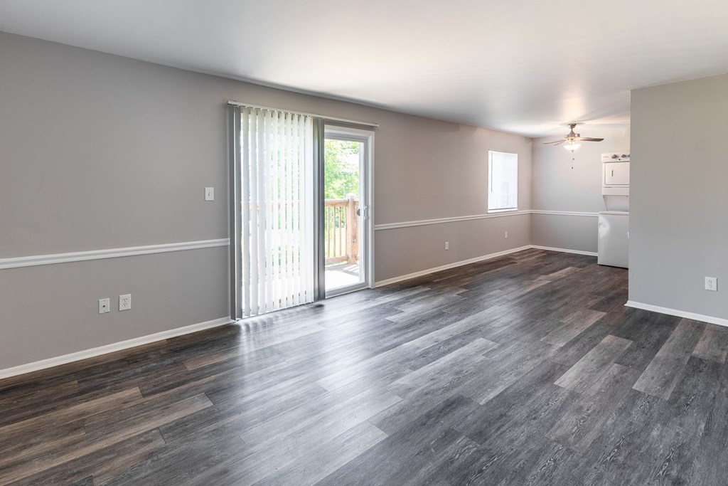 an empty living room with a sliding glass door to a balcony at Pickwick Farms Apartments, Indianapolis, 46260