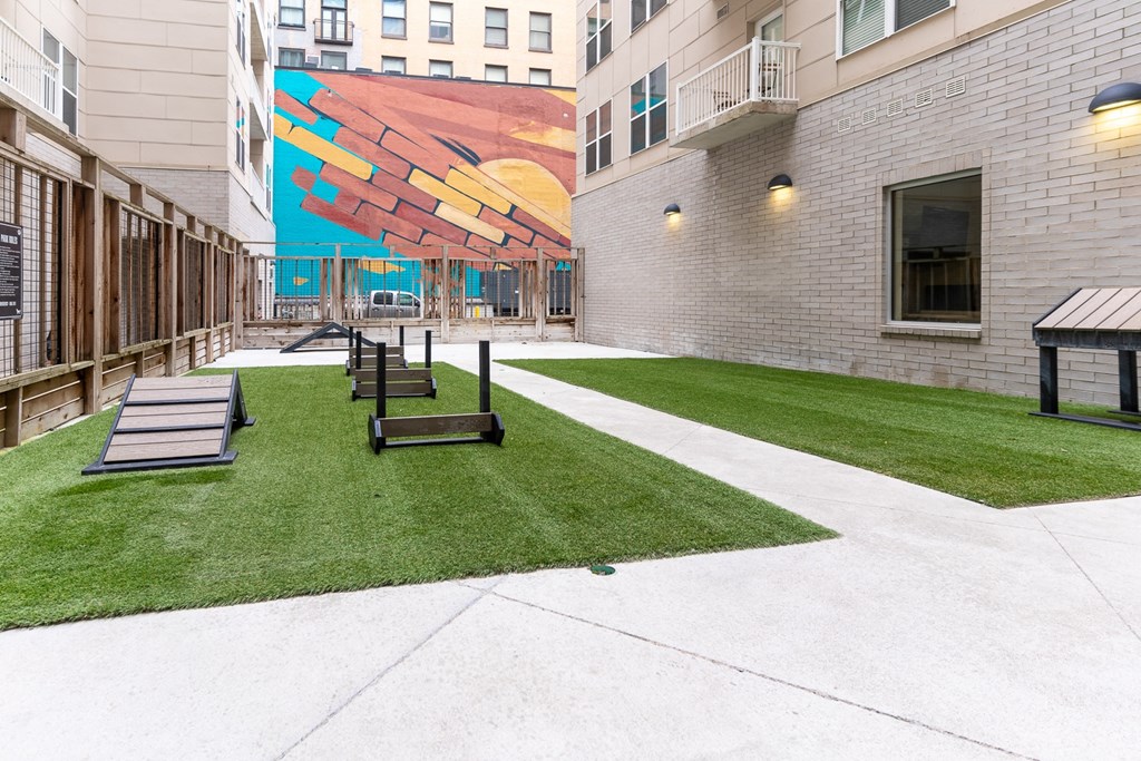 a courtyard with benches and a mural on the side of a building at The Whit Apartments, Indianapolis, Indiana