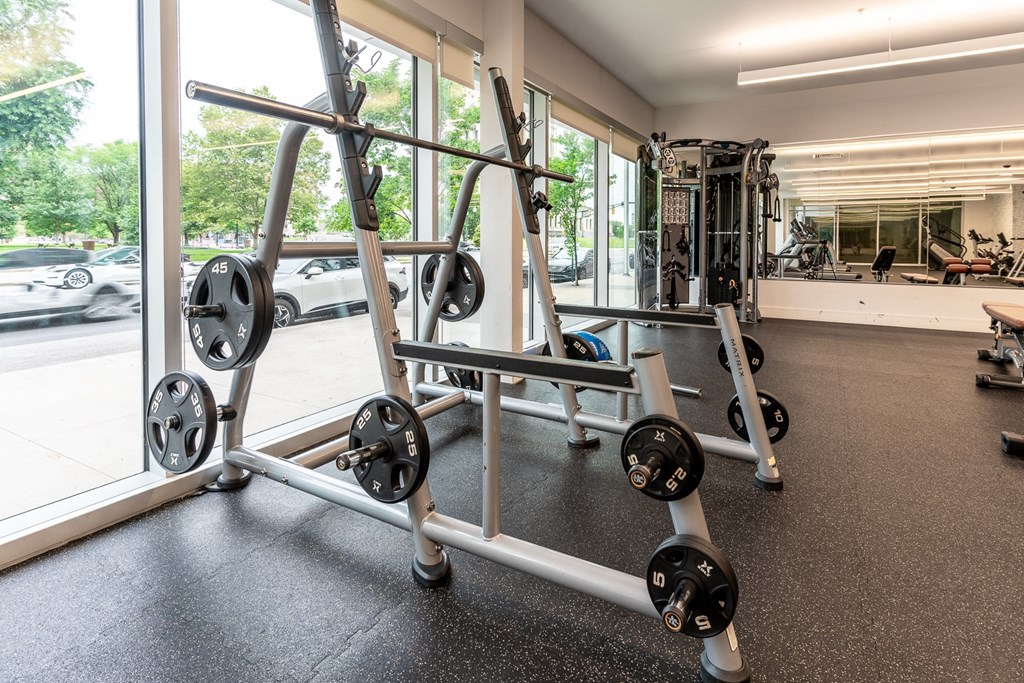a gym with weights and cardio equipment in a building at The Whit Apartments, Indianapolis, Indiana