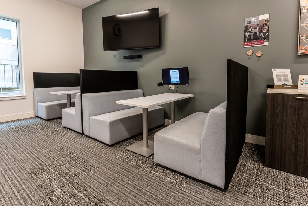 a living room with couches and a tv at The Whit Apartments, Indianapolis, IN