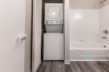 a laundry room with a washer and dryer and a tub in a bathroom at Walnut Creek Apartments, Indiana