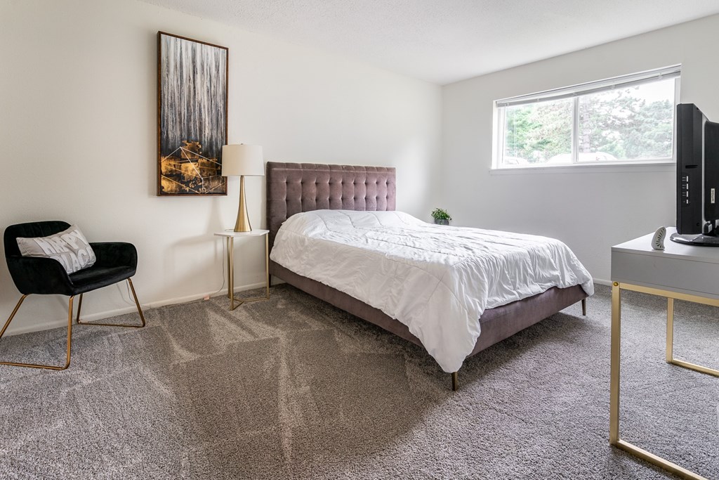 an apartment bedroom with a bed and a window