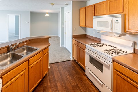 A kitchen with wooden cabinets and a white stove.