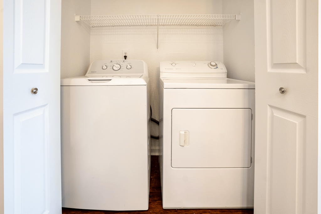 an empty laundry room with two washes and a dryer