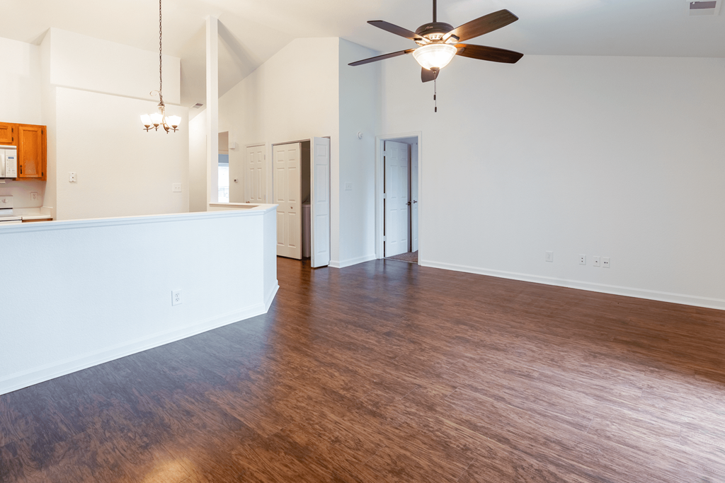 an empty living room with wood flooring and a ceiling fan at Barton Farms in Greenwood, IN 46143