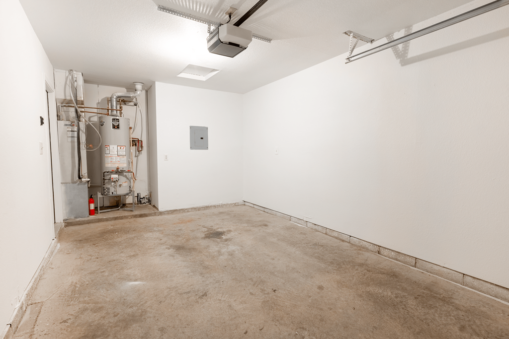 an empty room with a cement floor and white walls