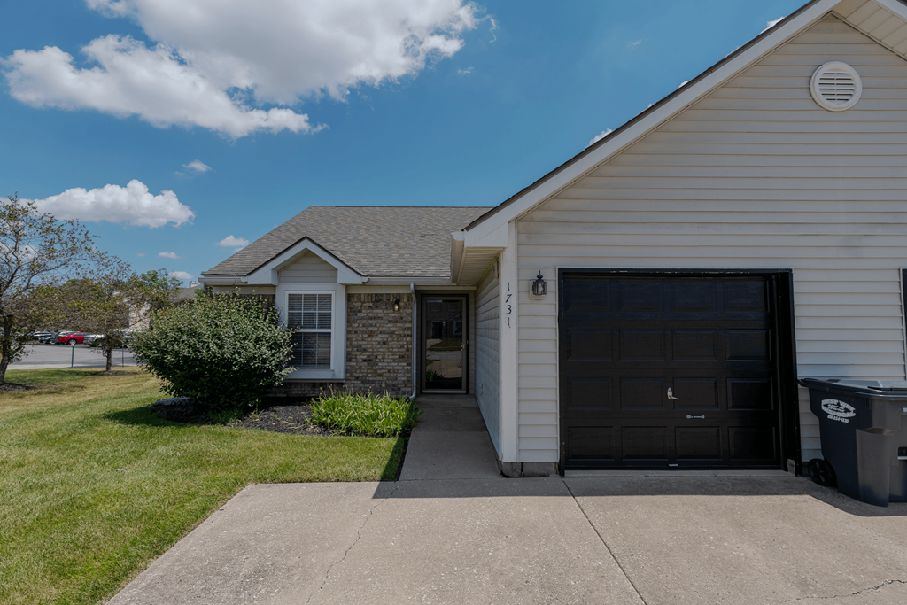 a white house with a driveway and a garage door at Barton Farms in Greenwood, IN 46143