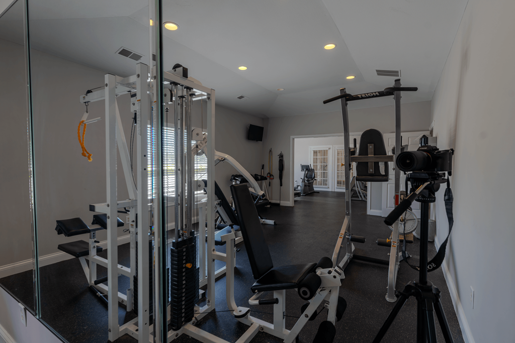 a gym with weights equipment and mirrors at Barton Farms in Greenwood, IN 46143